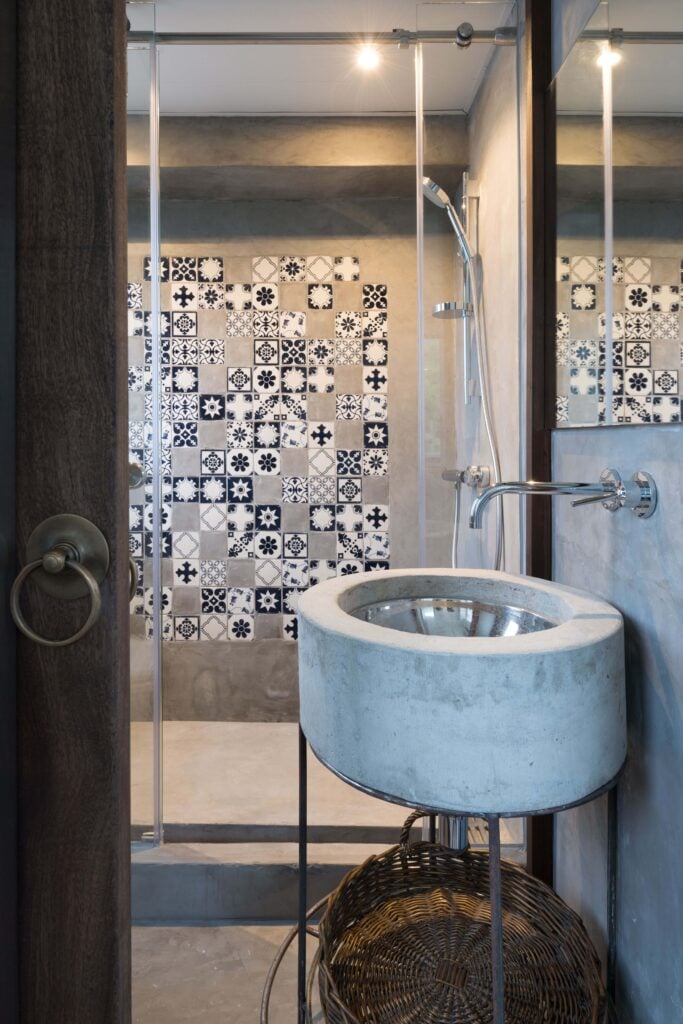 这里我们看到了淋浴空间，展示了复杂的瓷砖作品。水槽用混凝土包裹，符合房间的美学。