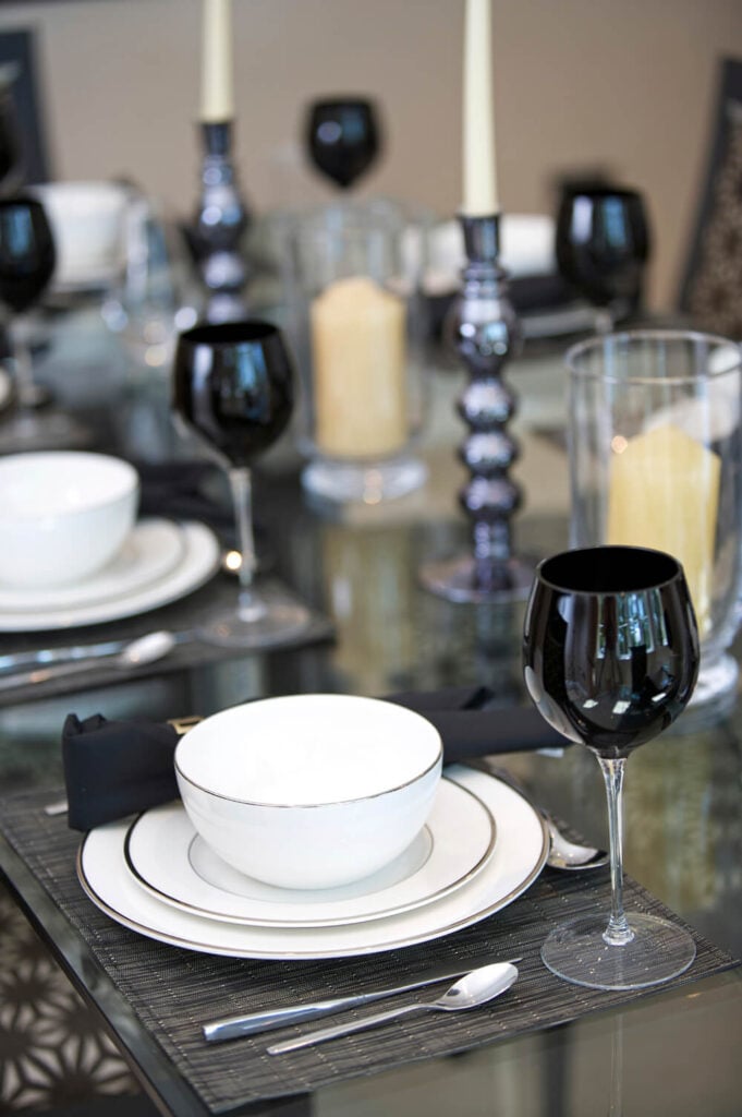 灰色和白色的桌子与黑色的口音。餐巾是一种更柔和的暗黑色，而酒杯的顶部是一种坚固的、有光泽的黑色，内外都有惊人的效果。