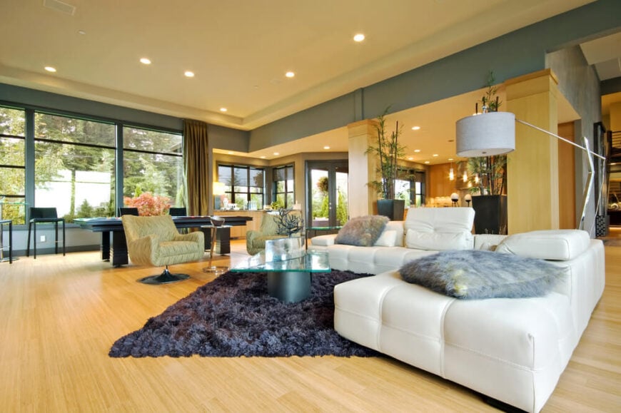 客厅里有很多不同的颜色。从白色到蓝灰色，金色的硬木地板并没有减少房间的口音，但它补充了它们。