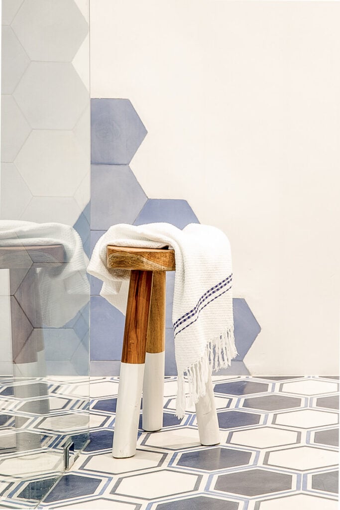 一个简单的木凳为这个完全现代化的主浴室增添了有机元素。