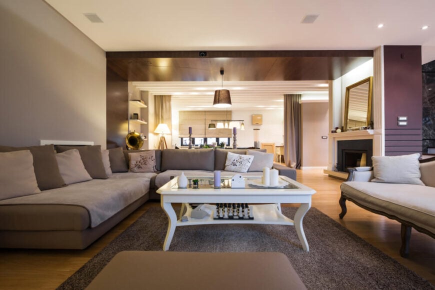 深紫色和灰褐色的色调赋予客厅清新而现代的氛围。浅色的硬木地板与深色的家具和木质天花板形成对比。