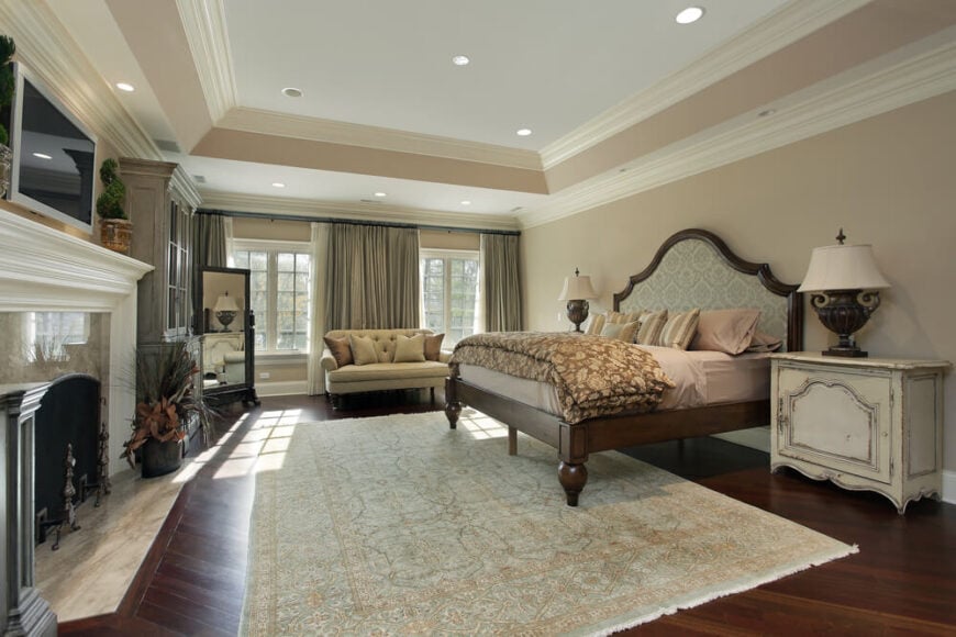 宽敞的卧室，硬木地板和庄严的壁炉。两扇大窗户嵌在房间后部的簇绒双人座椅后面。