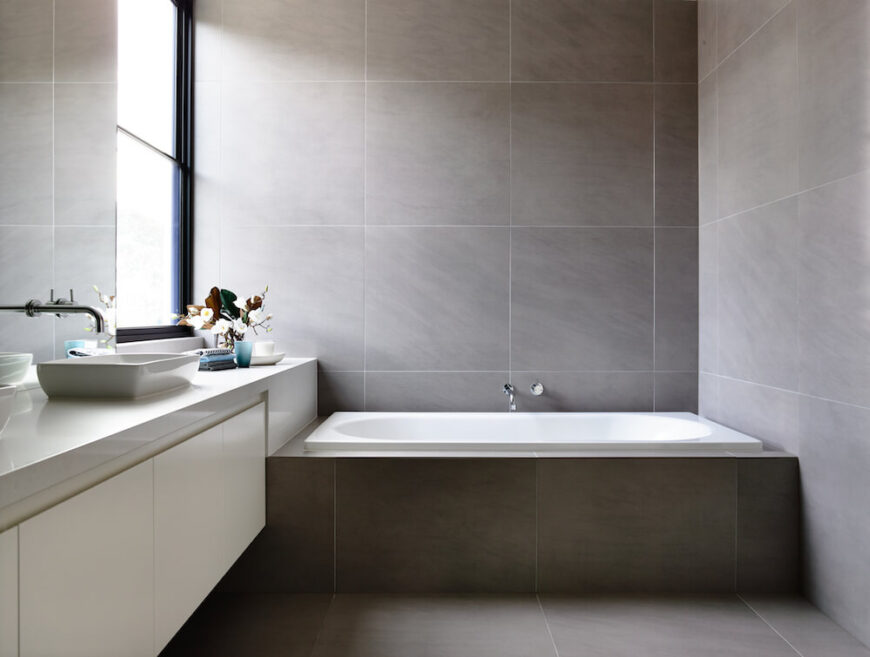 主浴室里有你想要的一切设施，包括宽敞的浴缸、水槽和光滑的棕色石头瓷砖。