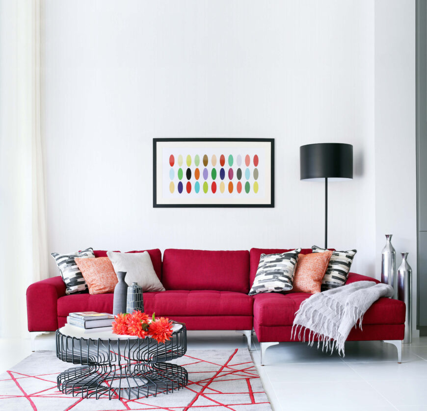 家庭活动室色彩爆棚，以现代剖面的丰富红色调为中心，这也体现在不对称的区域地毯图案上。轻工业咖啡桌拥有金属丝框架和白色表面，与光滑的白色地板和墙壁形成鲜明对比。