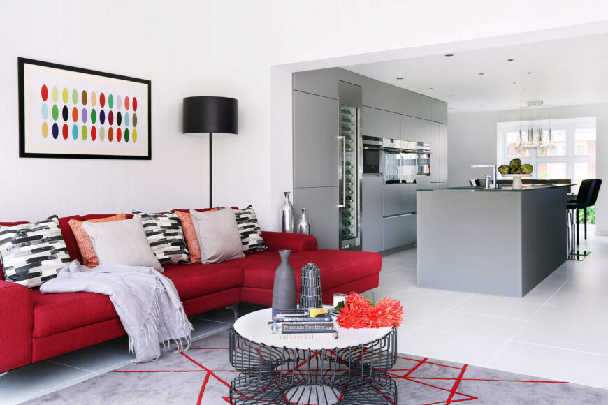 开放式的家庭房和厨房空间揭示了明亮的色彩和流畅的极简主义设计之间的二分法。