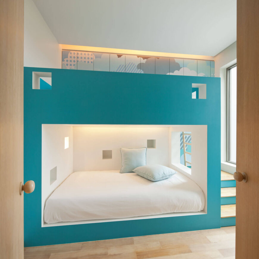 这个有趣的房间非常适合孩子们，明亮的蓝色和白色混合装饰着天然木材材料。房间的中心是一个巨大的双层床结构。
