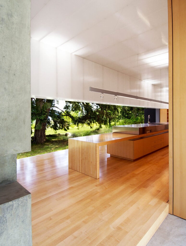 这个空间周围的丙烯酸墙板与中性混凝土和温暖的自然木材色调形成鲜明对比。
