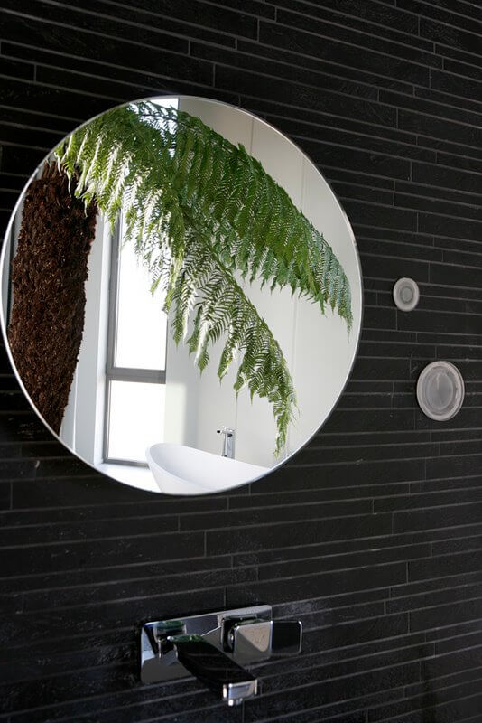 浴室镜子的特写显示了灯光与墙壁融合的时尚方式。