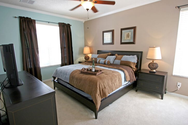 蓝色、棕色和炭色的卧室家具突出了一个既时尚又可实现的小卧室。深灰色的床、茶几和电视架与浅蓝色和棕色完美地搭配在一起，这个简单而优雅的空间。