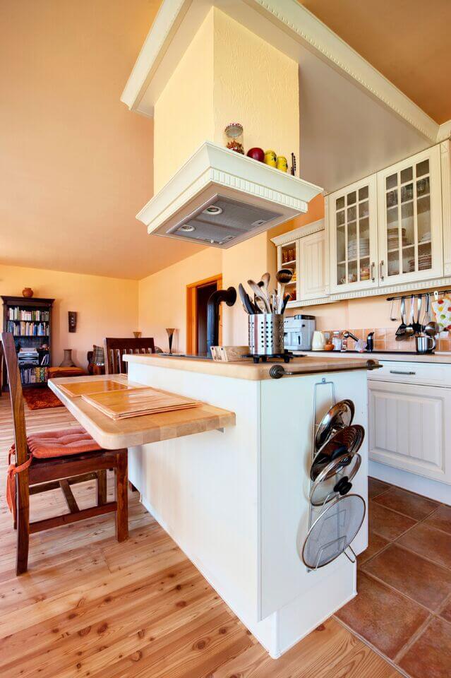 这个华丽的乡村厨房有一个惊人的天然硬木地板和双层岛。中性色的地板与白色的橱柜很相配。