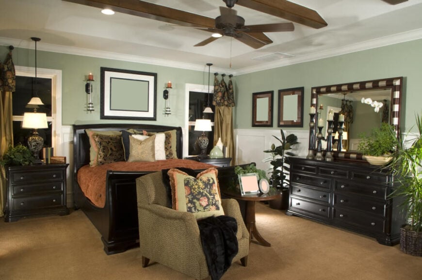 对于深色家具的卧室来说，“深褐色和米黄色”是很受欢迎的颜色选择，这间卧室完美地展示了这一点。深咖啡雪橇床的大小正好适合这个较小的卧室空间。协调的茶几和带有简单金属旋钮的镜像抽屉柜将整个外观联系在一起。不同深浅的大地色调和白色确保这个空间不会变得太暗和狭窄。