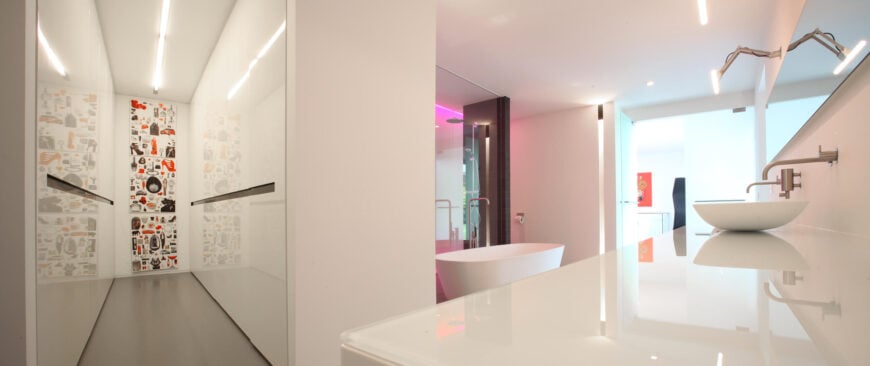 在这里，我们可以看到浴室的另一个角度，揭示了玻璃台面和容器水槽。注意霓虹灯从紫色到粉红色的颜色变化。霓虹灯的颜色变化为浴室增添了有趣的色彩。