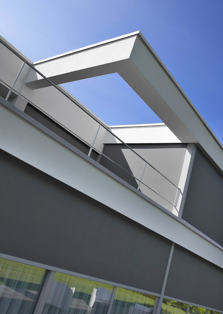 通过近距离拍摄，我们可以看到铝窗框、锌包层和独特的尖锐的结构线条，包括屋顶框架边缘的开放延伸。