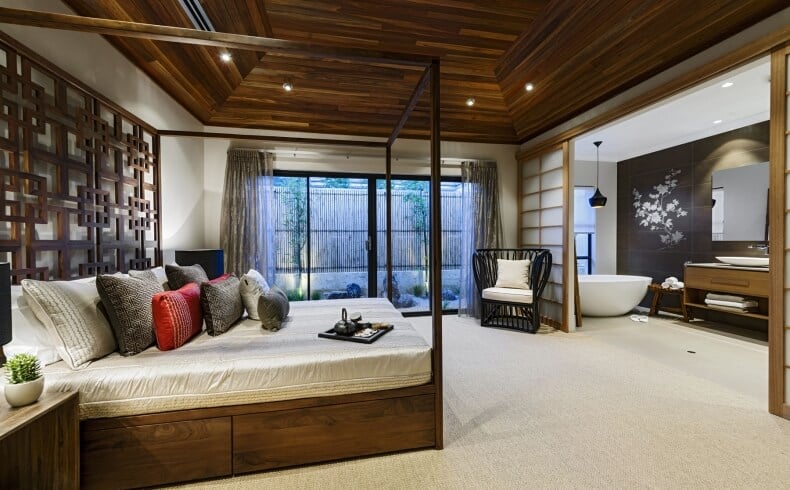 木质托盘天花板为这间亚洲风格的主套房提供了高度。Shoji门可以关闭可爱的禅宗主浴室套房。可爱的细长木制四柱床有一个华丽的床头板和存储