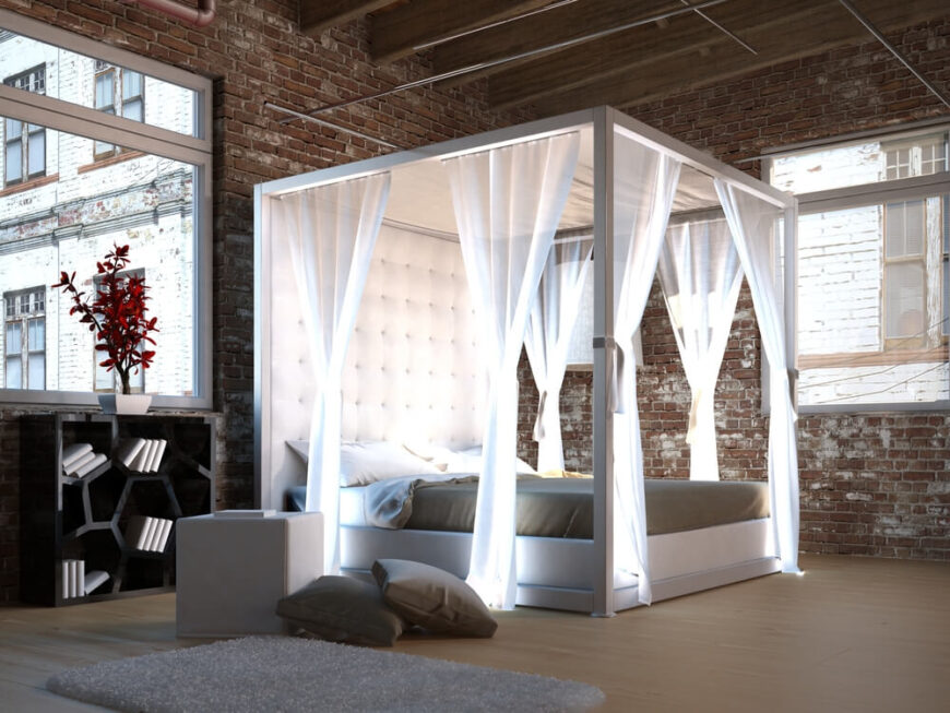 虽然整个空间裸露的砖块和金属制品赋予了它一种工业气息，但纽扣簇状床头板和明亮的纯白色窗帘为房间增添了更柔和的元素。
