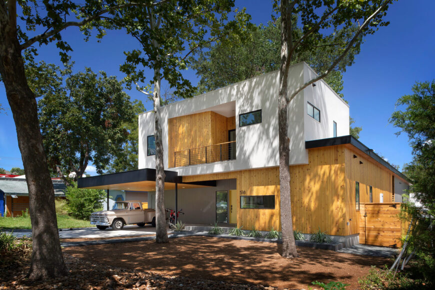 住宅的公众面以浮动的白色上层为特色，上面有丰富的天然硬木镶板。