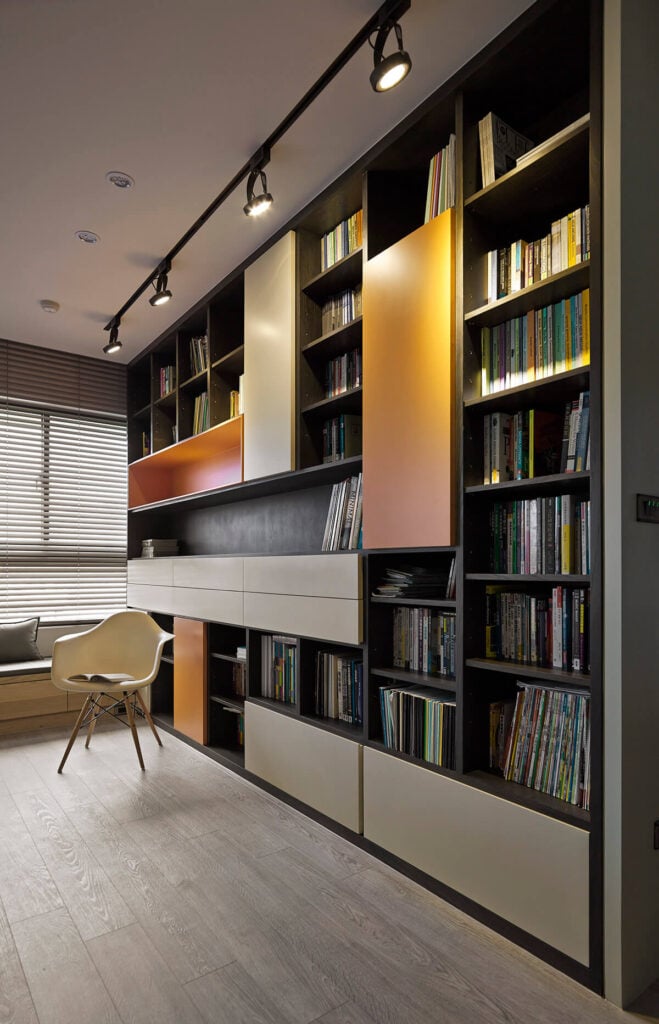 书架是宽敞的开放空间中的一个真正的中心项目，从地板到天花板都有一个不对称的开放式书架和封闭的柜子。橙色和米色的光滑面板为经典设计增添了至关重要的现代气息。