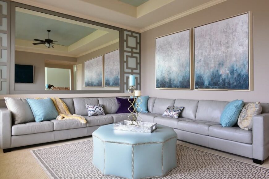 这个房间吊扇的深色与沙发和墙壁艺术品的淡银色以及整个房间的蓝色相抵消。