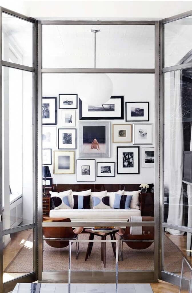 家具中丰富的棕色使冷色调变得温暖起来。浅蓝色和海军蓝的飞溅与单色的墙壁拼贴画形成了兴趣。