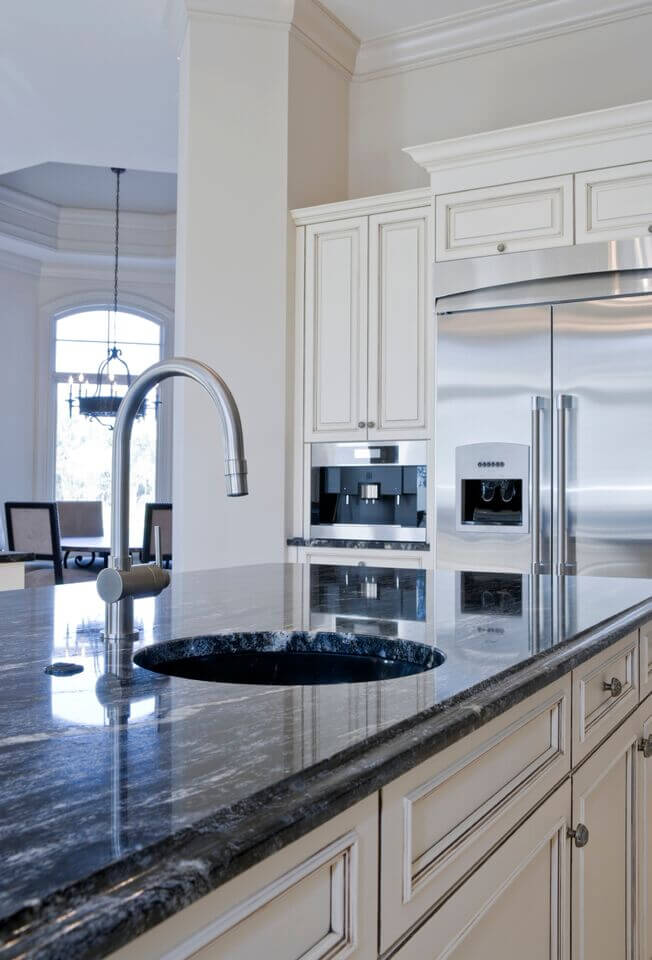 这里有一个更好的角度使用不锈钢来强调这个豪华的厨房。花岗岩华丽的青金石蓝色也可以在这里看到。使用深色的花岗岩是一种很好的方法，将强调色拉进厨房，而不需要装饰的反杂乱。