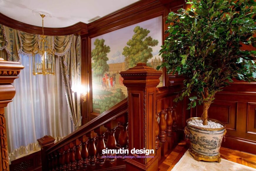 在楼梯的顶部，前一层的马赛克瓷砖过渡到豪华的镶木地板，上面覆盖着豪华的地毯。角落里有一棵装饰性的盆栽树，与远处壁画中的大树形成互补。