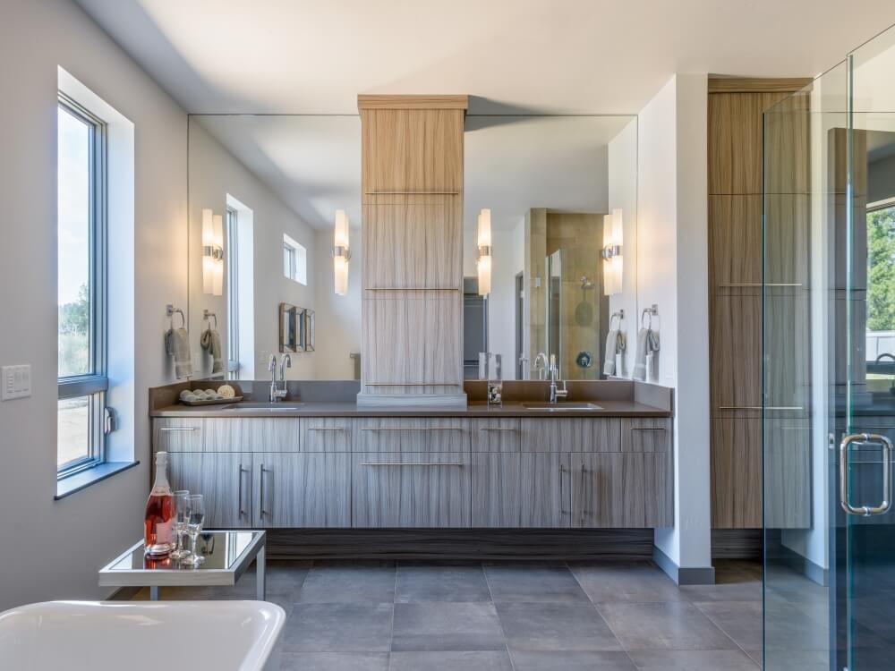 大型主浴室设有一个仿乡村风格的浴室梳妆台，带有两个水槽、镜子和大量的存储空间。该空间还包括瓷砖地板、一间独立浴缸和一间步入式淋浴间。房间由壁挂灯和一扇大窗户照明。