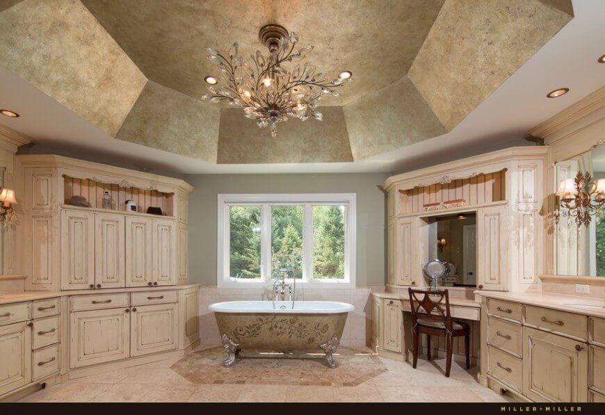这个巨大的浴室空间被高高的拱形天花板放大，并由一个大型水晶吊灯强调。爪足浴缸位于窗户下方的中心，外表面有详细的图案。浴缸和柜台之间有一个大梳妆台。