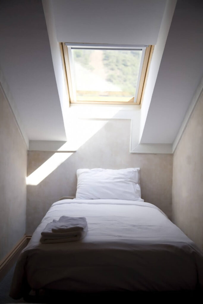 在这样一个小空间里，增加一个床头板会让空间感觉更小。事实上，位于床正上方的天窗有助于打开这个小的睡眠区域。