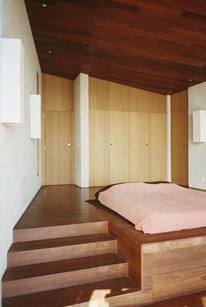 这个流线型的最小卧室包含大量的存储空间，隐藏在视线之外。在这里加上床头板会破坏这个可爱而简单的设计的干净线条。