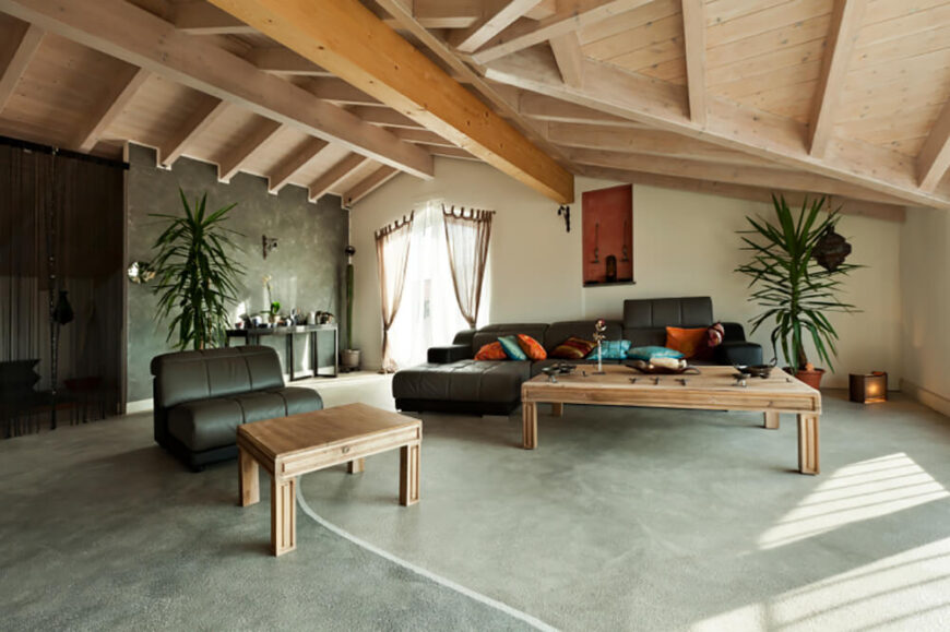 浅色的原木和混凝土地板让这个空间感觉鲜明而开放，但巧克力棕色的家具和明亮的橙色、蓝绿色和绿色的飞溅温暖了房间，抵消了基础材料的冰冷感。