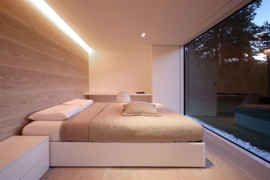 这个可爱的极简主义卧室让室外的景色成为房间的橱窗。圆滑的线条和低调的家具保持了房间的禅宗般的低调氛围，这将与任何东西都不同，除非是木质的强调墙。
