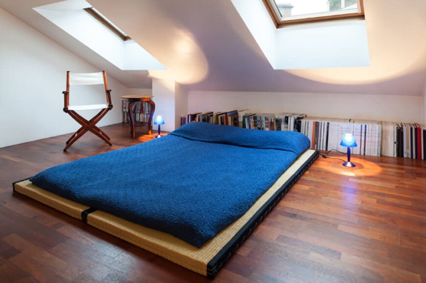 这种简单的榻榻米和蒲团床垫的设置是一种简单而有效的方法，可以建立一个易于移动的小睡眠空间，这样就不会占用可能需要做其他事情的空间。将书沿墙排列，利用了原本空无一物的空间。