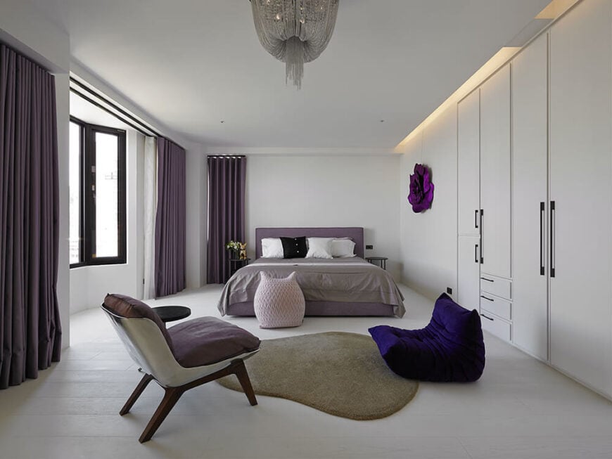 主卧室包括大胆而柔和的紫色色调，以活跃房间的白色基础。床前的区域是为阅读和放松而设计的，同时可以欣赏到外面山区景观的大凸窗。