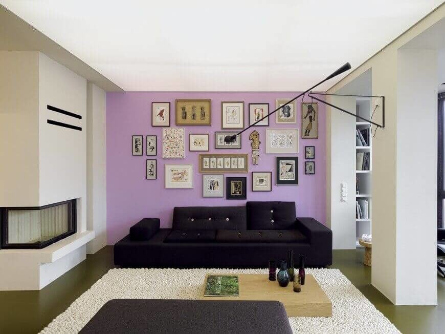 这面淡紫色的强调墙充满了一系列的版画和艺术作品，几乎占据了整面墙。