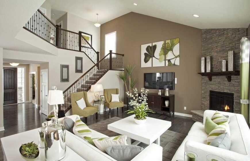 这个华丽的客厅具有统一的调色板，深棕色的地板，白色的沙发，和浅绿色的飞溅。色彩微妙的抱枕的加入使白色家具充满活力。