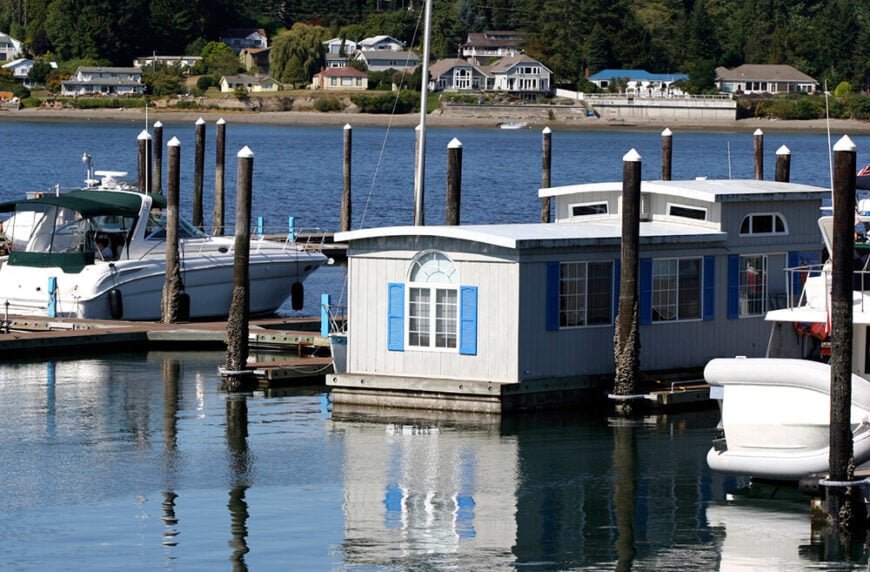 这艘船屋停泊在码头上，就像一个放在大木筏上的预制房屋。