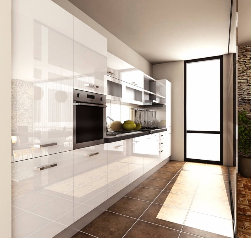 窄小的厨房里有光滑光滑的白色橱柜和不锈钢小家电。深棕色的石头瓷砖地板与极简主义的设计形成对比。厨房和外面更有异国情调的房间之间隔着一道薄薄的屏障。