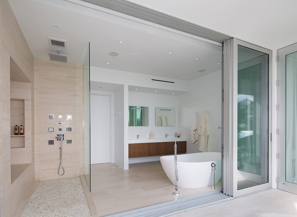 大型主浴室设有独立浴缸，周围环绕着白色墙壁和开放式淋浴区。