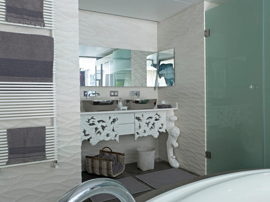 主浴室自然是三个浴室中最优雅的一个，里面有一个大浴缸，四周是有质感的白墙。华丽的梳妆台里有一对镀铬的容器水槽，旁边是一个烟熏玻璃淋浴罩。