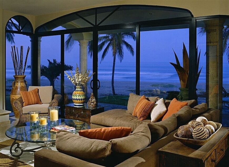 落地窗和玻璃推拉门一起，让这间客厅可以看到海滩的广阔景色。装饰上复杂的图案赋予了空间特色，而围绕玻璃咖啡桌的家具提供了最佳的舒适性。
