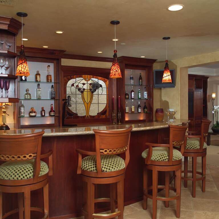 这个酒吧配备了丰富的木椅，与酒吧和搁架单元的材料相匹配。在两个置物架之间有一段彩色玻璃，很好地突出了空间。