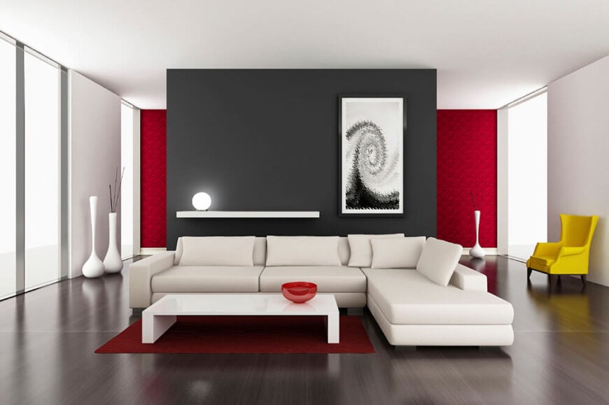 一种现代设计，具有强烈的色彩对比。白色沙发放置在深色的材料地板上，而黑色的墙壁与周围的白色墙壁和天花板形成对比。清爽的表面营造出现代的氛围。