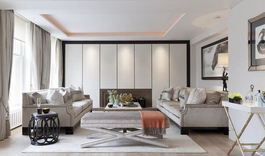 灰色的家具与褪色的硬木地板相得益彰。这个客厅充满了中性色，并由人造光和自然光照明。只有小的装饰性花朵和白色的红色毯子用色彩强调了空间。