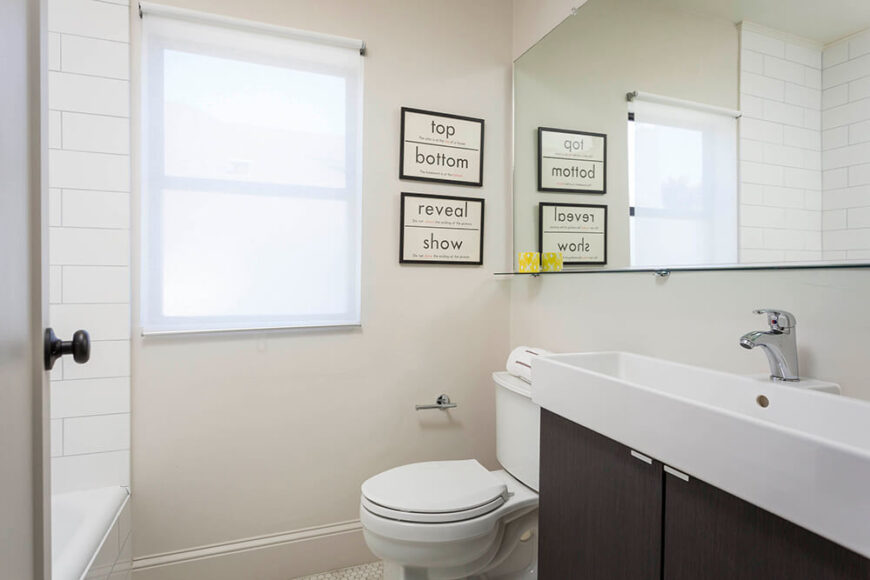 浴室的特色是简单的白色瓷砖地板，下面是一面巨大的无框镜子，淋浴间包裹着地铁瓷砖。梳妆台的特点是一个槽式容器水槽。