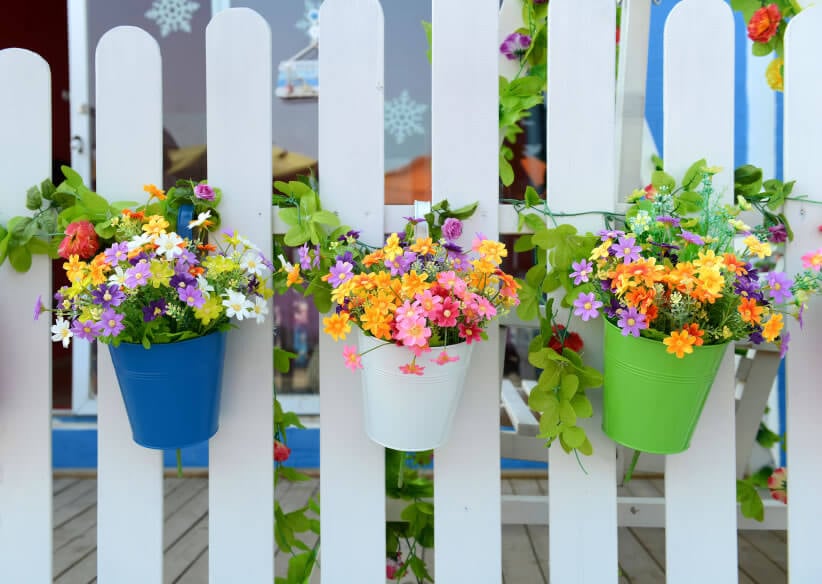 在传统的白色尖桩栅栏，颜色的飞溅，在彩色的罐子和分批的花的形式，帮助把平静的白色变成一个令人兴奋的丰富的色调。