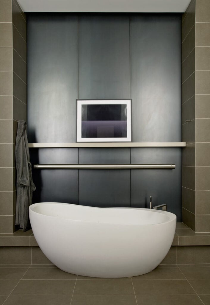 套间主浴室设有这个令人惊叹的独立式浴缸，以及一个独立的淋浴间和一个步入式衣橱。金属刷墙的使用降低了温暖的瓷砖的温度，并突出了房间其他部分的白色浴缸。