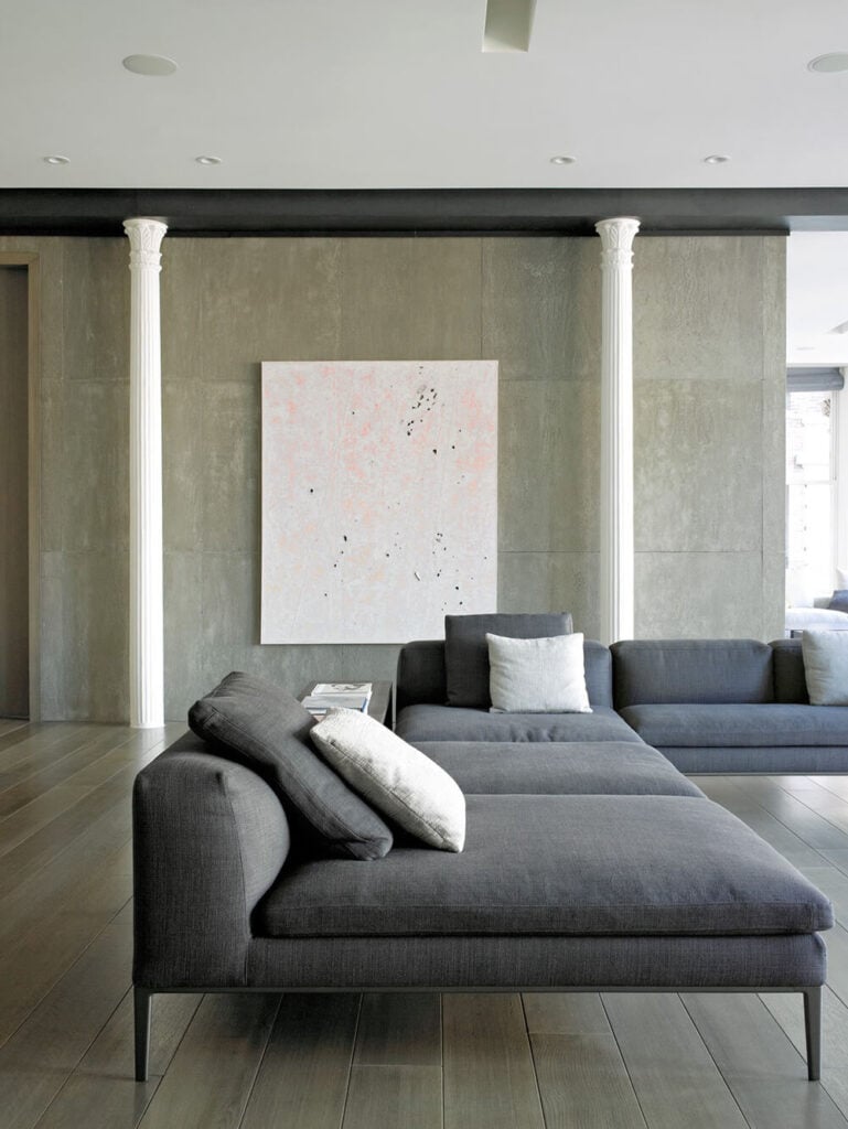 大组合家具占据了客厅的大部分空间，但由于低背和长靠垫，它保持了低调。微妙的色彩在墙上的艺术品中发挥作用，模仿沙发上抱枕的颜色。