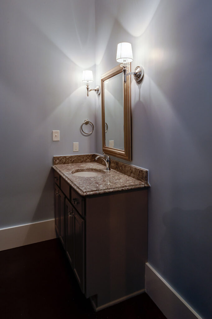 与其他房间一样，附属浴室的墙壁上也使用了相同的颜色，大大增加了房间的亮度。同样的现代灯具也突出了浴室的镜子，但一个打火机柜让房间看起来不会太小。