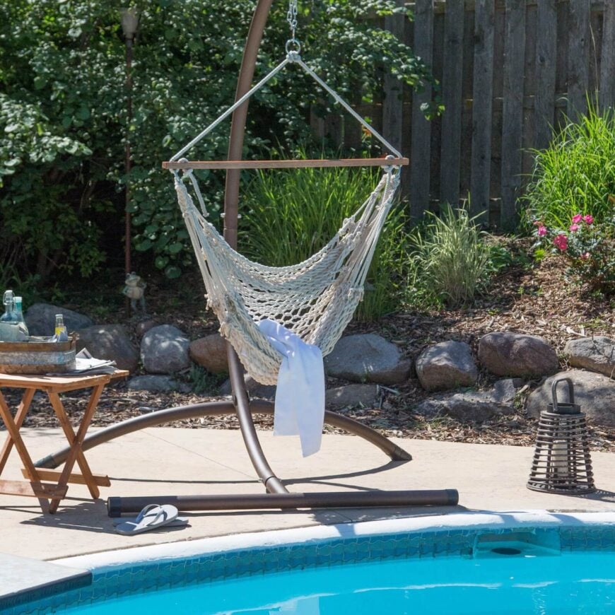 游泳池边有一张吊床椅，有坚固的支架。开放式编织是完美的感觉微风和干燥后，在游泳池浸。