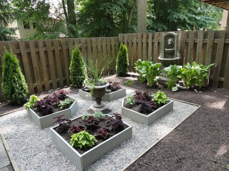一个容器花园甚至可以包括更小的凸起的种植箱。这个花园的维护费用很低，用覆盖物和鹅卵石代替了草坪，还有一些彩色的小种植床。